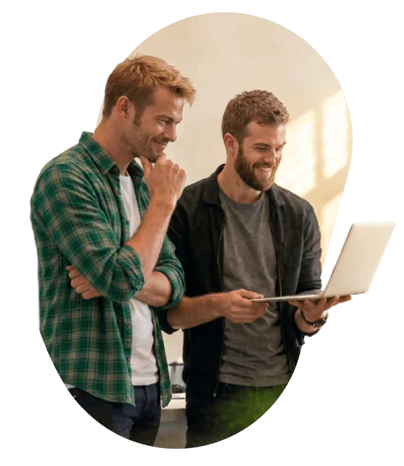 Two engineers smiling at a laptop screen