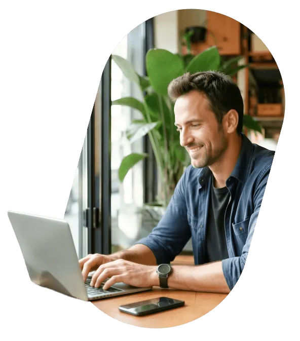 A smiling founder working on a laptop at a desk