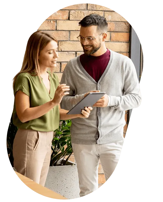 Two colleagues looking at a tablet together in an office