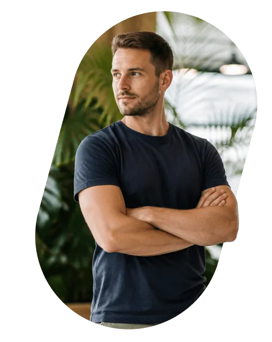 A founder standing with arms crossed in a plant-filled office