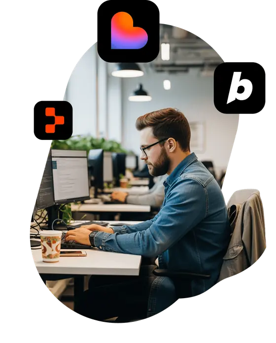 A developer working at a desktop computer, surrounded by the Lovable, Bolt and Replit logos